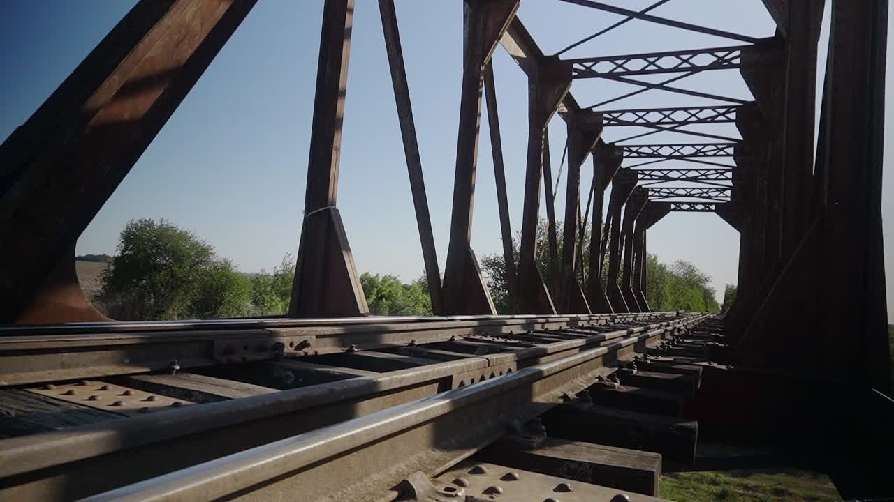 Low-angle, wide view of a railway bridge in a rural area