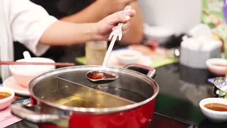 cooking hotpot soup with ladle and ingredients