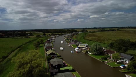 aerial drone 4k footage travelling over some boat travelling along river yard, norfolk