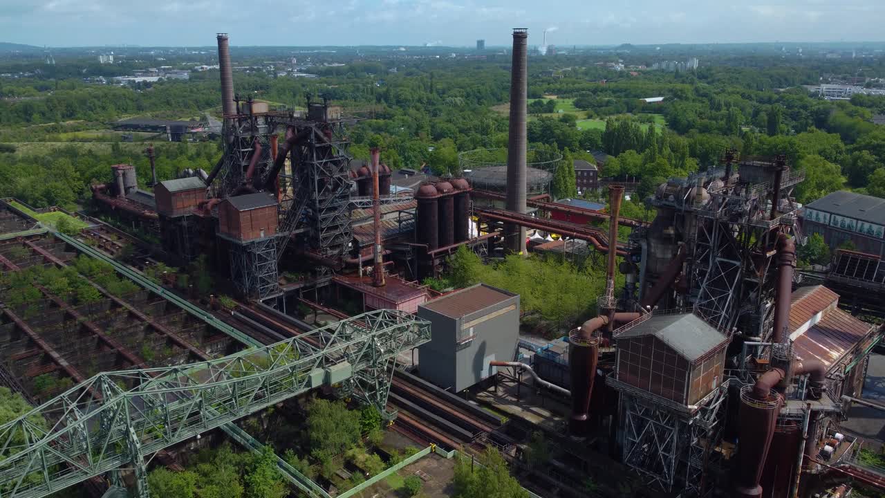 muy vieja fábrica misteriosa con dos chimeneas muy altas que salen un montón de tuberías que pasan a través y alrededor de la ubicación de este lugar pequeños edificios casas construidas en construcciones sala de control