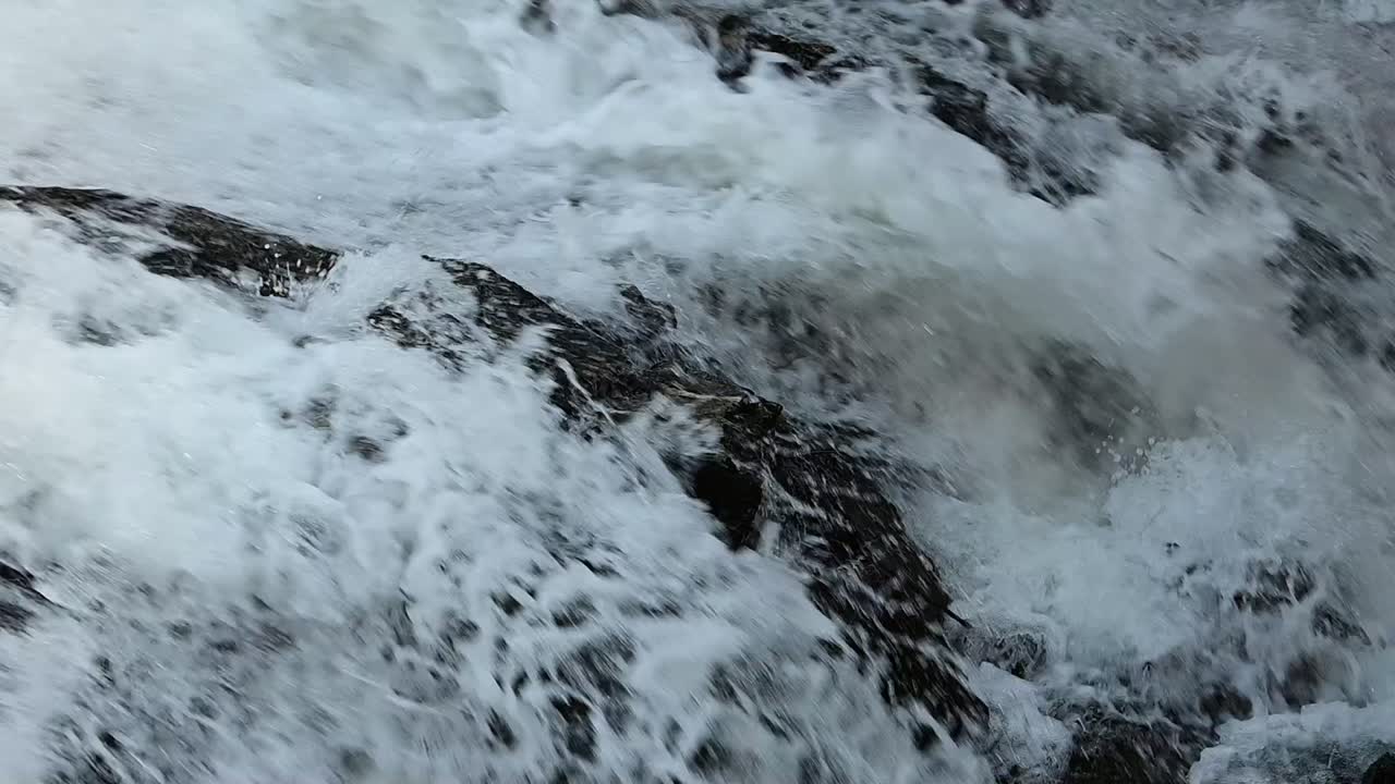 산의 바위 위로 흐르는 빠른 물