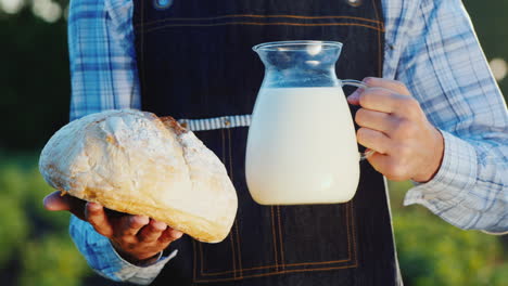 un granjero sostiene una jarra de leche y un pan de loba alimentos orgánicos saludables