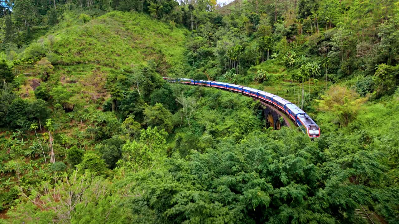 Stunning aerial drone footage of a train crossing the iconic Nine Arches Bridge in Ella, Sri Lanka.