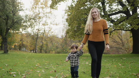 mom and son are walking in the autumn park