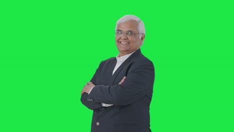 Portrait-of-Happy-Indian-senior-journalist-standing-crossed-hands-Green-screen