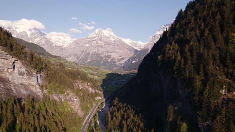 aerial drone footage pushing in and raising down at entrance of swiss mountain village grindelwald, picturesque views of swiss alps