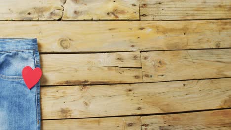 cerrar los vaqueros con un corazón rojo en un fondo de madera con espacio de copia