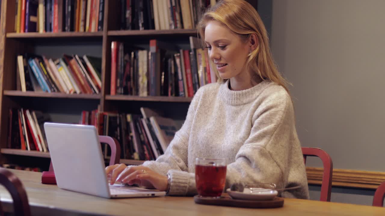 attraktiv kvinde i jumper ved hjælp af bærbar computer