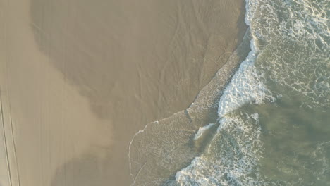 top view of a beach shore with white sand and blue water waves on the beautiful island, fraser island, australia