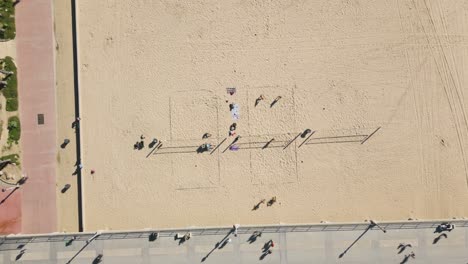 Vistas-De-La-Playa-De-Huntington-Con-Este-Cautivador-Lapso-De-Tiempo-De-Drones,-Que-Muestra-A-Los-Bañistas-Jugando-Voleibol-Y-Paseando-Por-El-Paseo-Marítimo-Y-El-Muelle