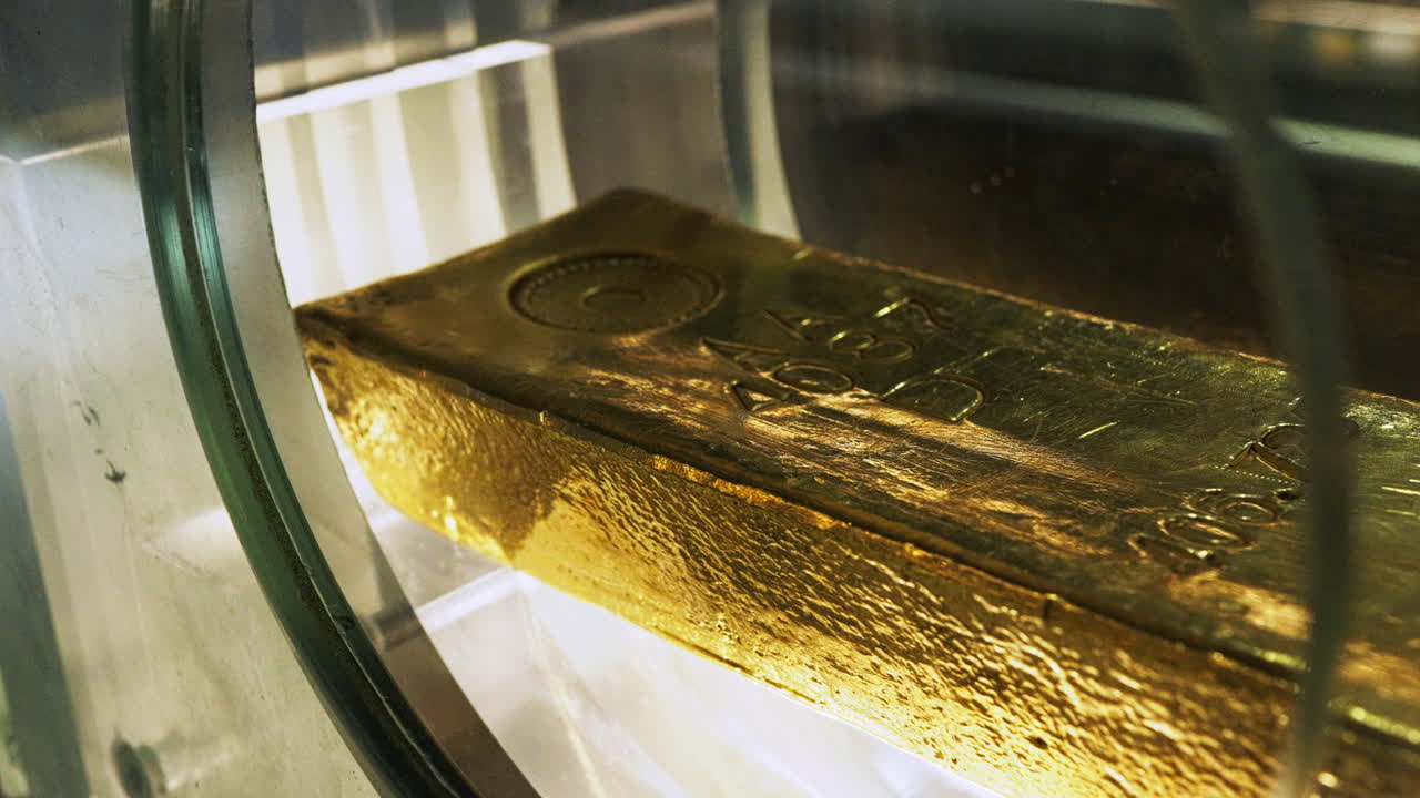 Macro shot of a heavy fine gold bar, resting in a bank or safe, symbolizing high value, investment, or wealth.