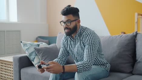 man playing video games on a couch