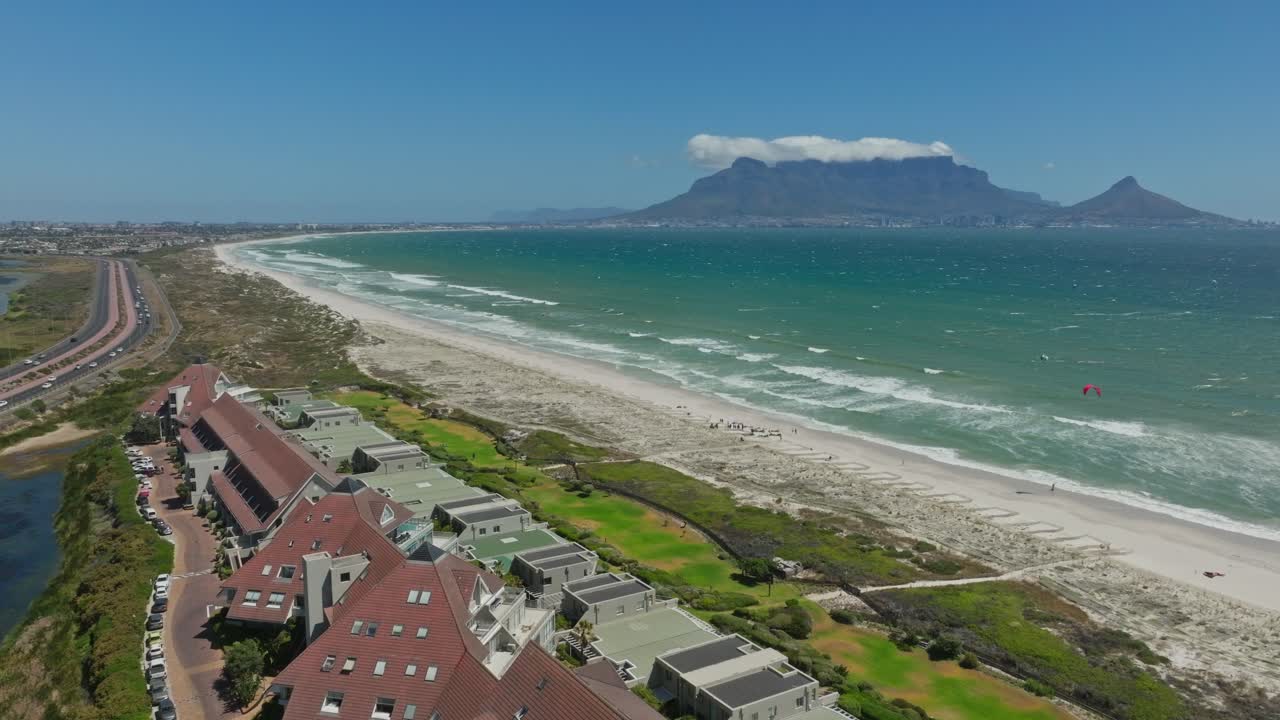 테이블 마운틴을 볼 수 있는 아름다운 카이트 서프 스포트 돌고래 해변의 드론