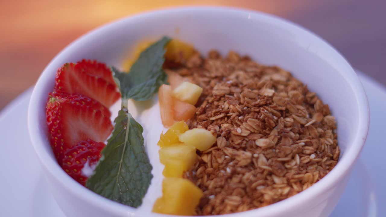 un delicioso plato de desayuno saludable lleno de frutas frescas, cereales y yogur