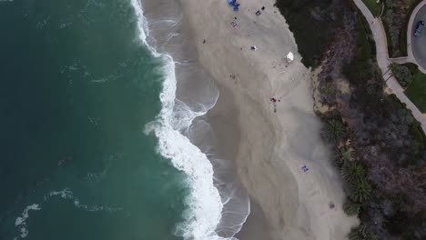 Toma-De-Arriba-Hacia-Abajo-De-La-Ola-En-Laguna-Beach-Inclinándose-Hacia-Un-Hotel-Beach-Resort