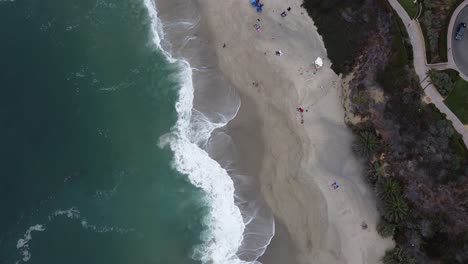 toma de arriba hacia abajo de la ola en laguna beach inclinándose hacia un hotel beach resort