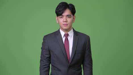 joven y guapo hombre de negocios asiático señalando a la cámara