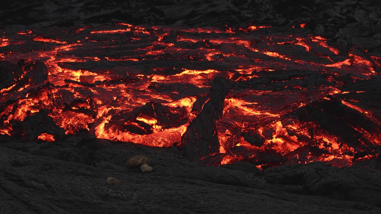 Paysage préhistorique avec de la lave s'écoulant à travers la roche noire