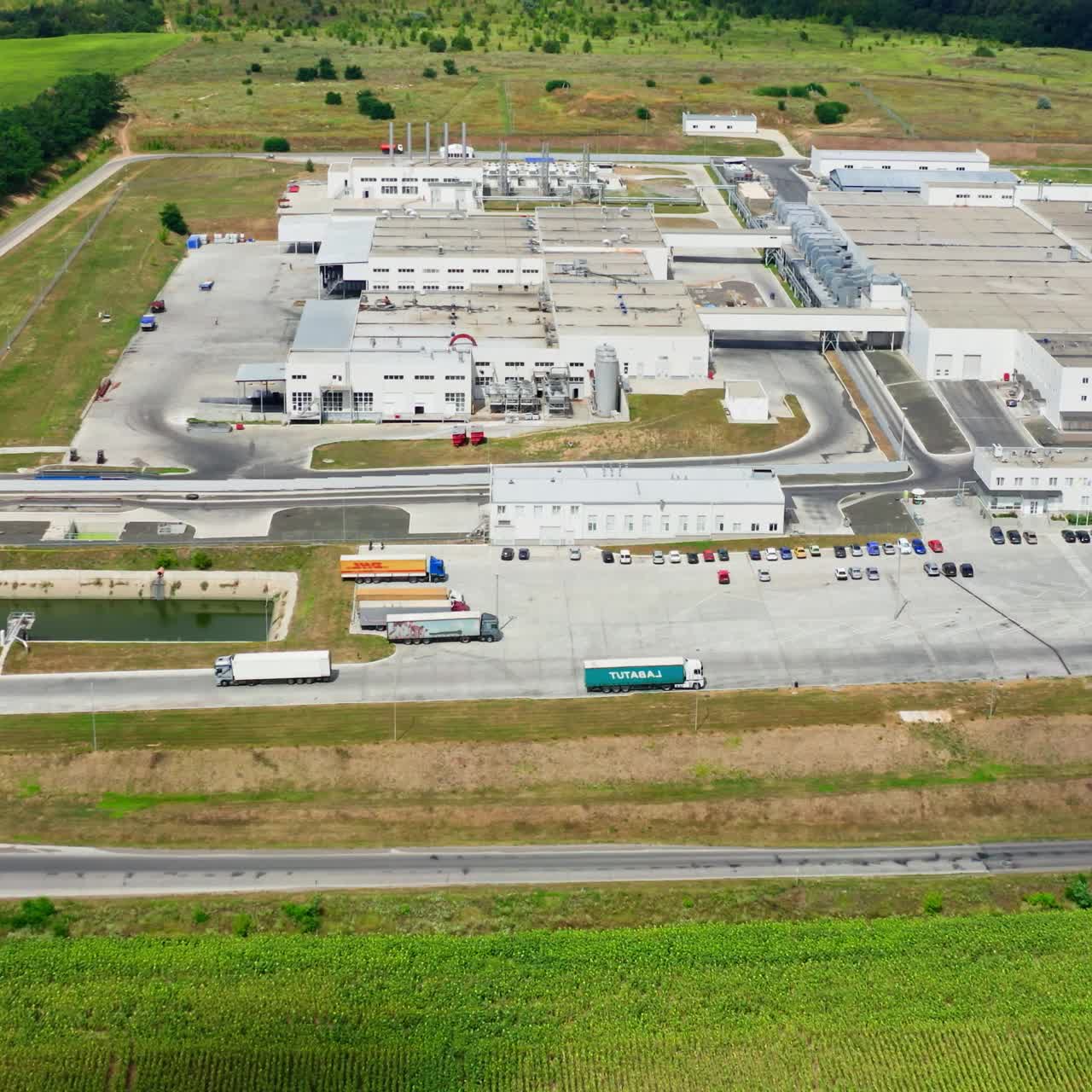 Large industry on green environment. Modern factory surrounded by nature. Industrial territory in the countryside. Aerial view
