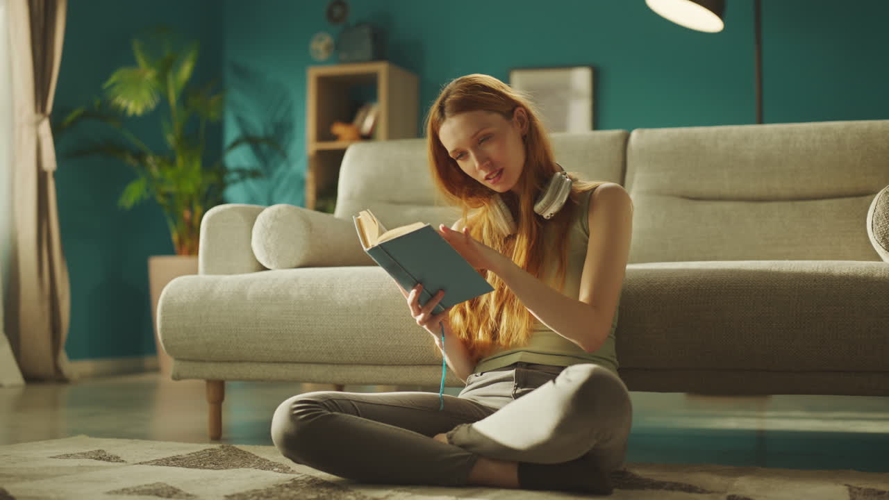 Woman sitting on floor and reading book