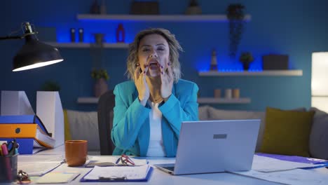 Home-office-worker-woman-looks-at-camera-with-happy-and-smiling-face.