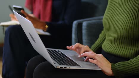 executive using laptop on sofa in office 4k