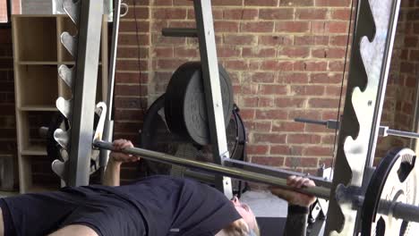 Muscly-man-in-home-gym-exercising-decline-smith-machine-bench-press