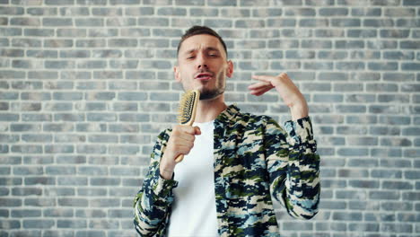 man singing with a hairbrush microphone