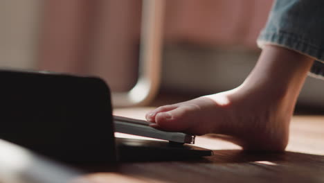 child musician bare foot presses pedal of electronic piano