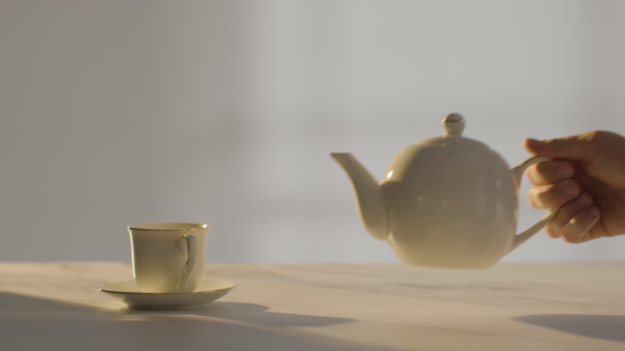 fotografía de estudio de una persona que hace una taza de té británica tradicional usando una tetera