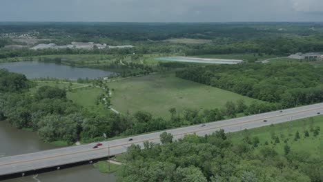 stationary drone shot of an american highway in the midwest with a river in the background in the summer