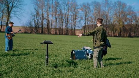 group playing music outside. young band play musical instruments on field