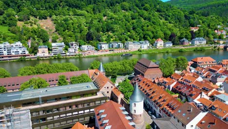 4k aerial drone video of historic homes, shops, and churches along the neckar river in downtown heidelberg, germany