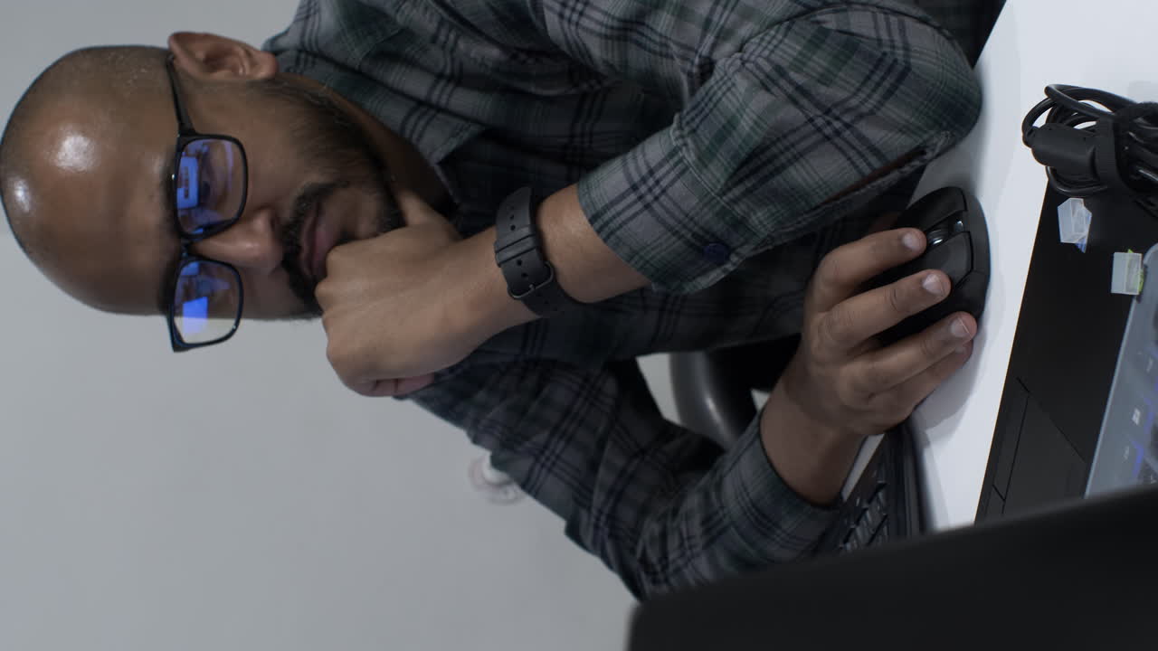 Close up shot of an Indian entrepreneur reviewing a business document on a computer, making small corrections as he proofreads the details and content of the document