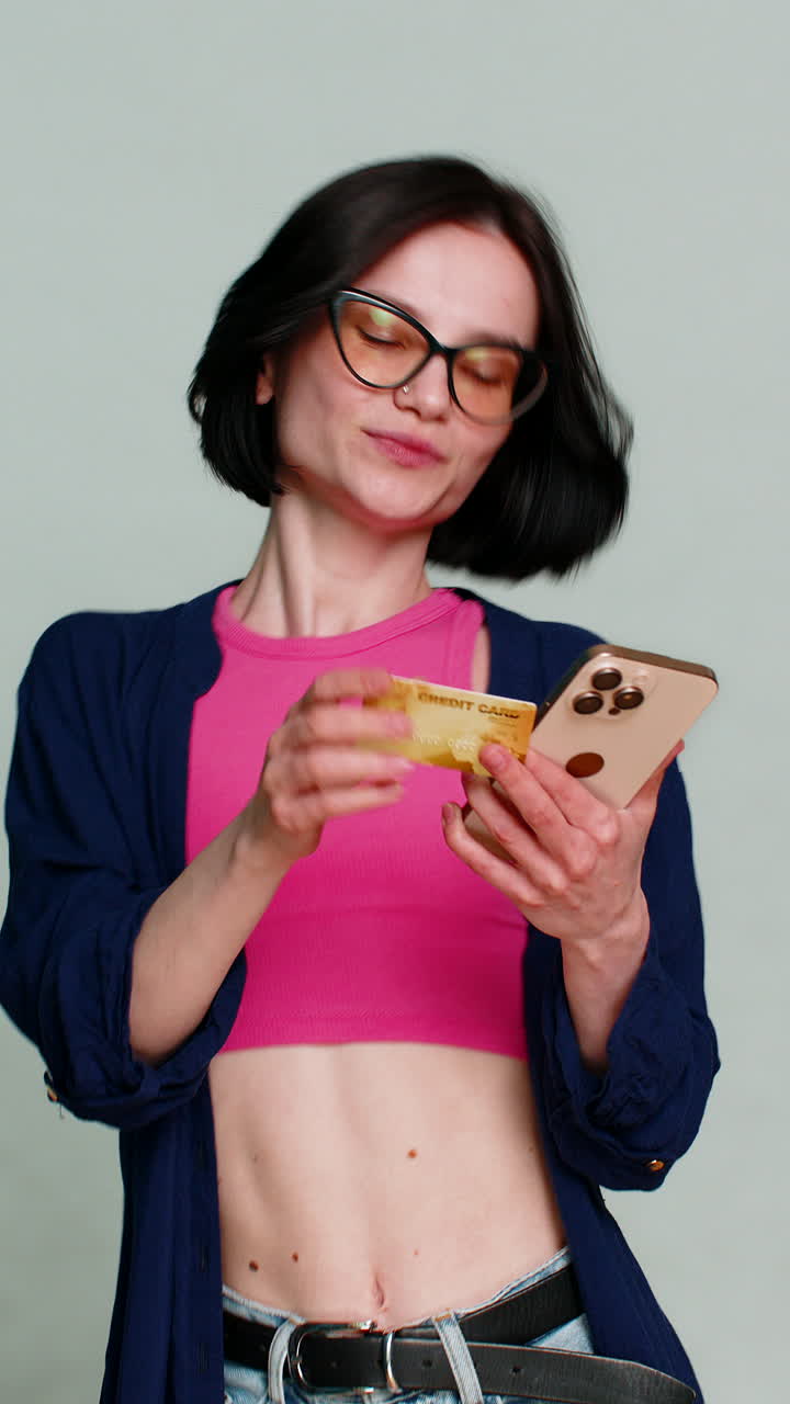 Woman smiling holding credit card pointing to camera clearly indicating shopping payment gesture