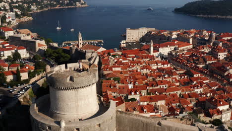 old city walls with minceta tower and old harbour of dubrovnik in croatia - aerial drone shot