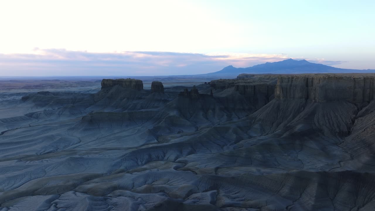 paisaje aéreo cinematográfico de factory butte, utah al atardecer, hombre de pie en la roca