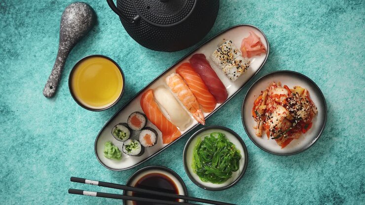 asiatisches lebensmittelsortiment verschiedene sushi-rollen auf keramikplatten