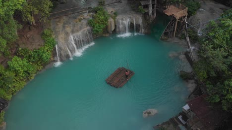 La-Niña-Está-Remando-En-Una-Balsa-De-Bambú-En-Las-Cataratas-De-Cambugahay-Siquijor,-La-Isla-De-Filipinas,-Antena-Cinematográfica-De-Drones-En-4k