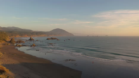 La-Gente-Disfruta-De-La-Puesta-De-Sol-En-La-Playa-En-Port-Orford,-Costa-De-Oregon---Toma-Aérea-De-Drones