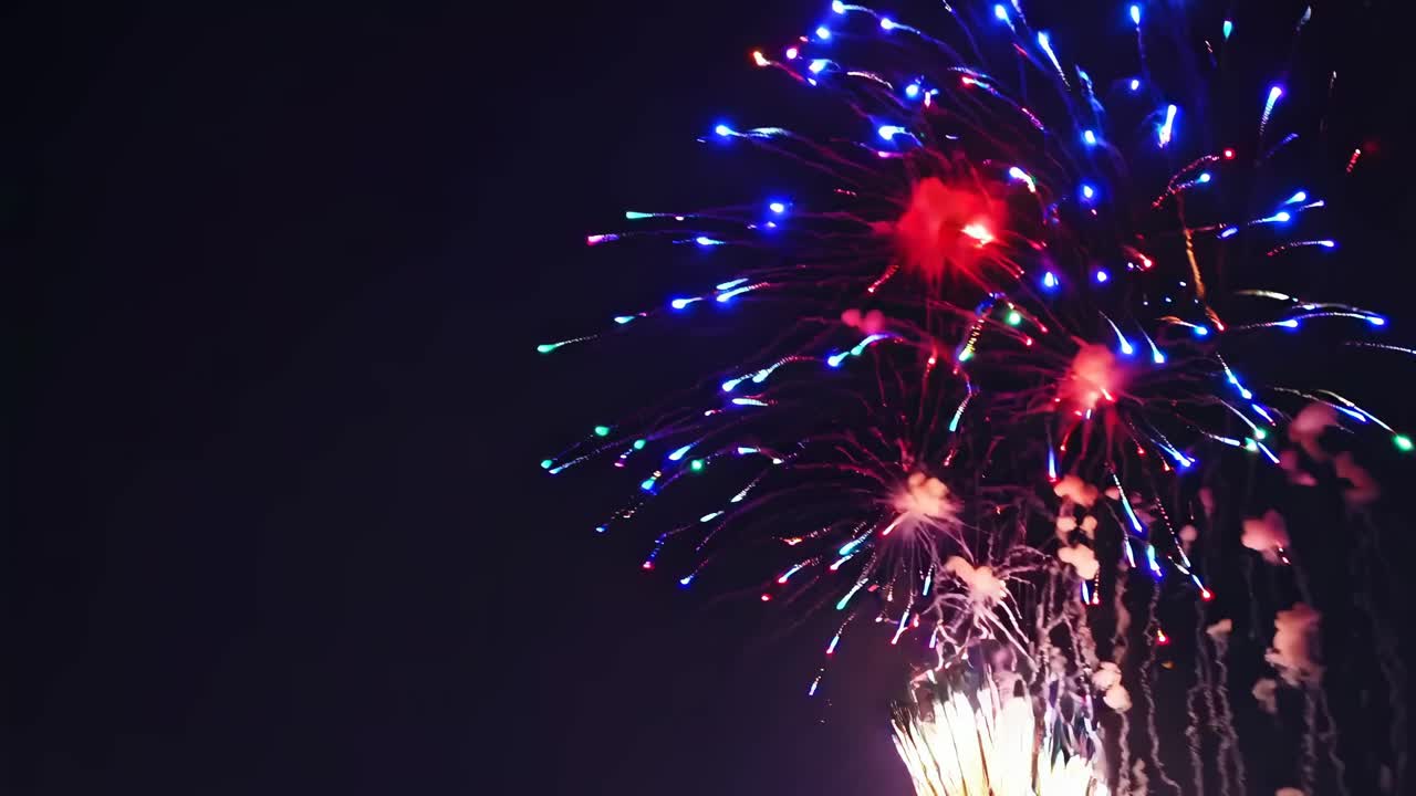 A vibrant video captures fireworks bursting in the night sky from a low-angle perspective