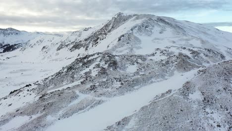 Aerial-View-of-Snow-Capped-Hills-on-Cold-Winter-Day-and-High-Elevation-Landscape-on-Rocky-Mountains-Range-USA