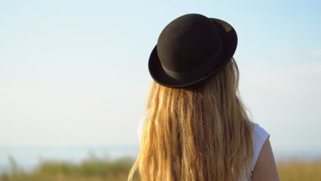 woman in a hat and sunglasses outdoors