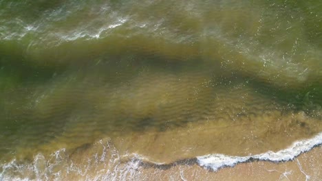 tropical beach aerial view, top view of waves break on tropical white sand beach. sea waves seamless loop on the beautiful sand beach.