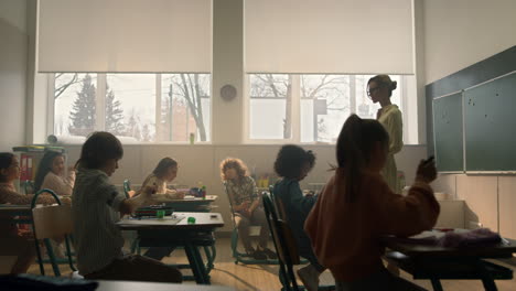 niños aprendiendo en clase escolar. maestra de pie frente a la clase