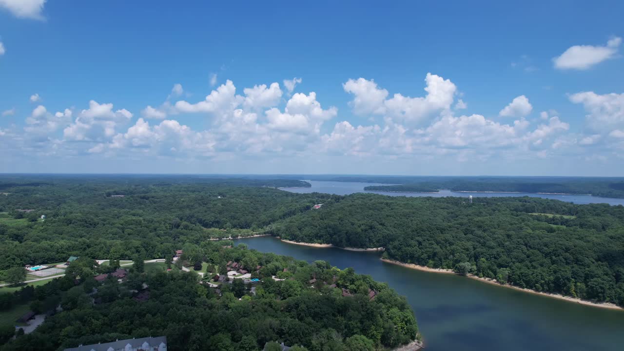 青い空を白い雲が満たす、明るい夏の道にあるモンロー湖の空撮