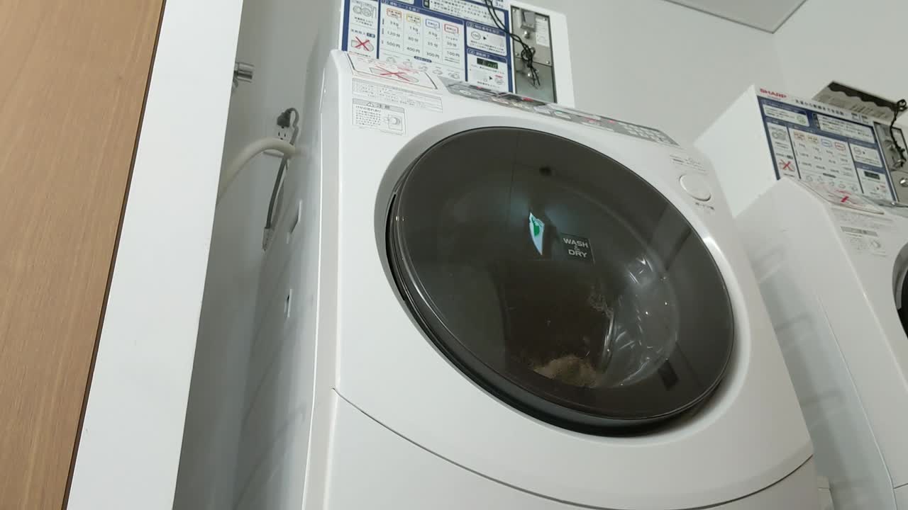 A commercial coin-operated Japanese combo washing machine-dryer combo doing exactly what it's made to do