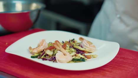 el cocinero decora la ensalada con camarones