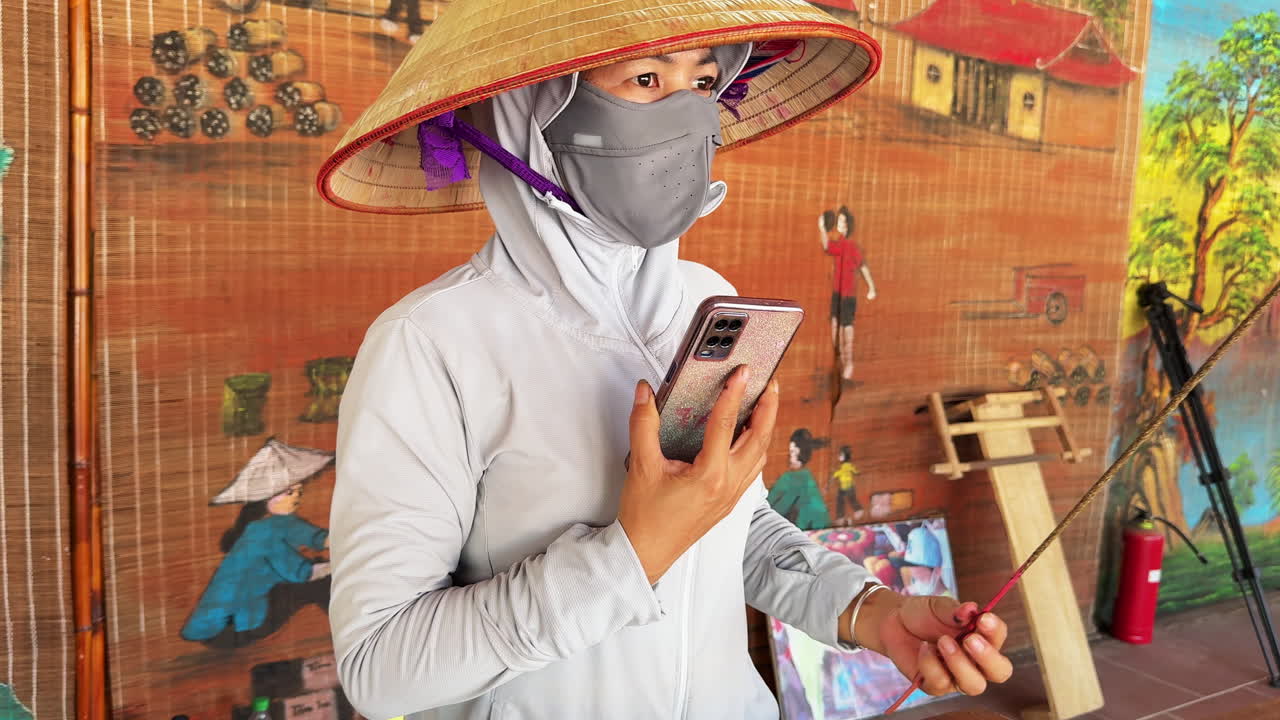 Traditional Vietnamese Woman with Conical Hat, wearing face mask and talking on the phone
