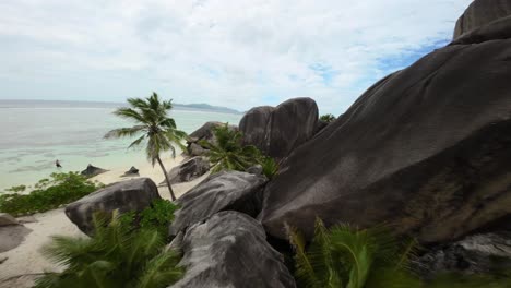 fpv drone flying on a anse source d'argent beach in seychelles on an island mahe, video of incredible trees, seychelles rocks, seaside, and surrounding seychelles landscapes